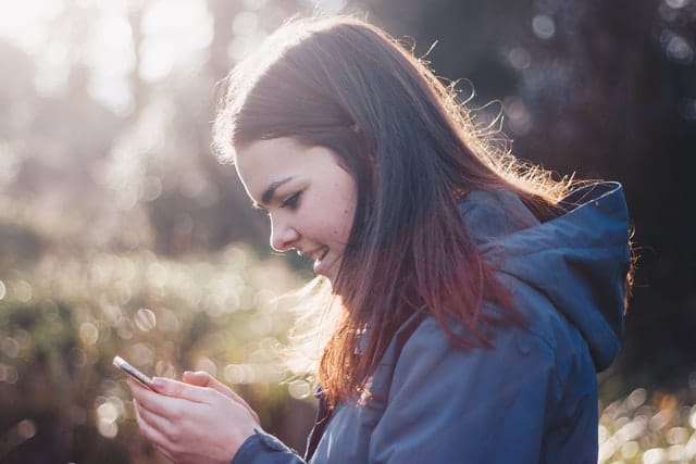 image of girl smiling while texting on lesbian dating app