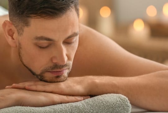 man lying massage table spa salon