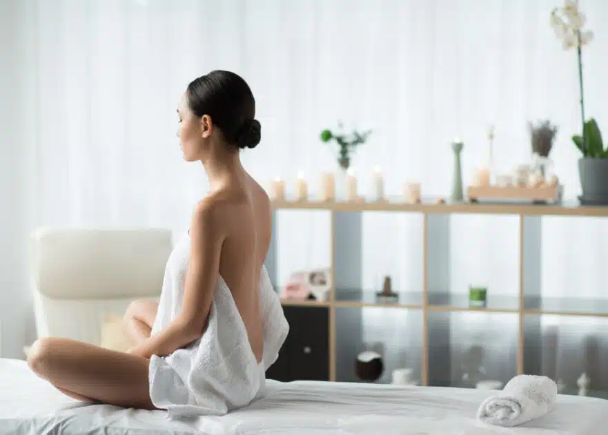Woman in bed receiving massage and meditation
