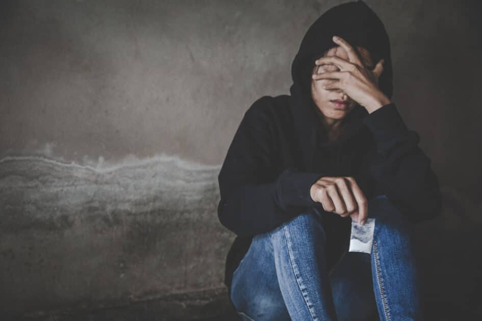 Depressed and despairing adolescent girl sitting alone after doing drugs, Drug addiction and withdrawal symptoms,