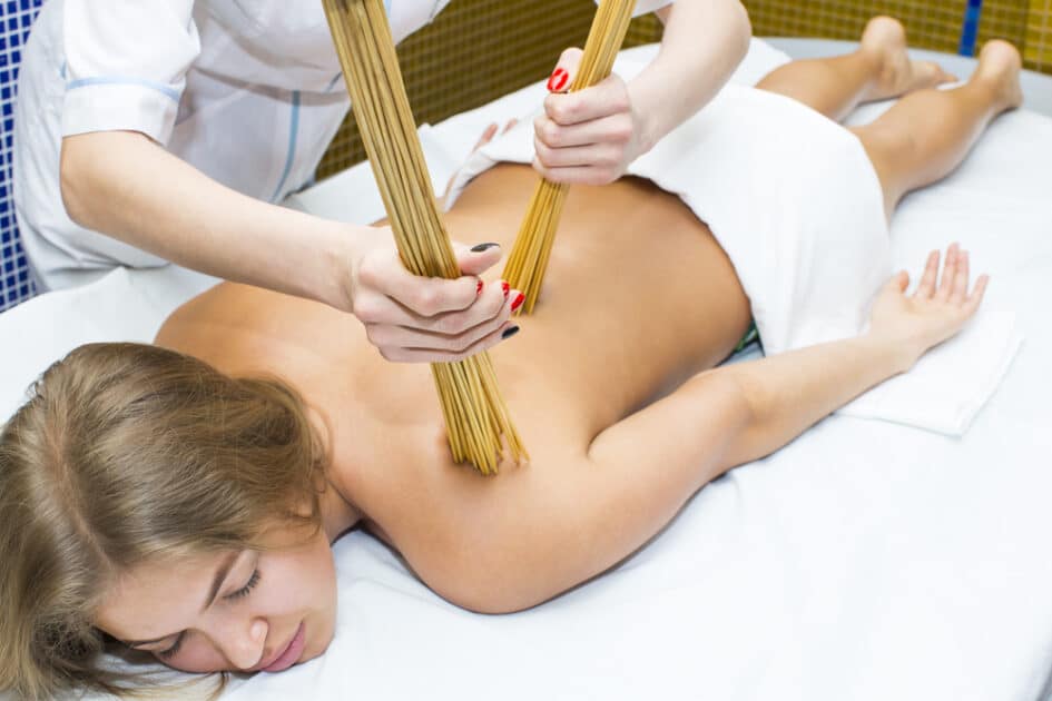 In a spa salon, a Japanese massage using bamboo sticks is performed.
