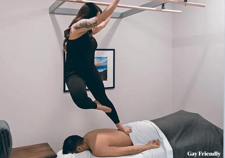 A female therapist gives a male client an Ashiatsu massage.