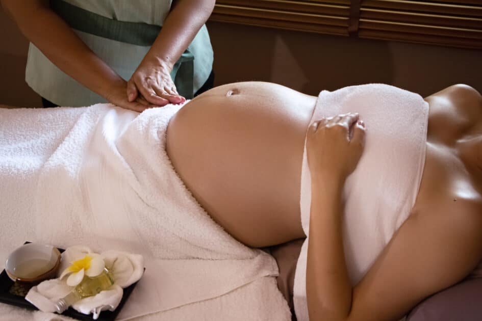 The therapist is massaging a pregnant woman as part of a treatment and relaxation program at a spa.