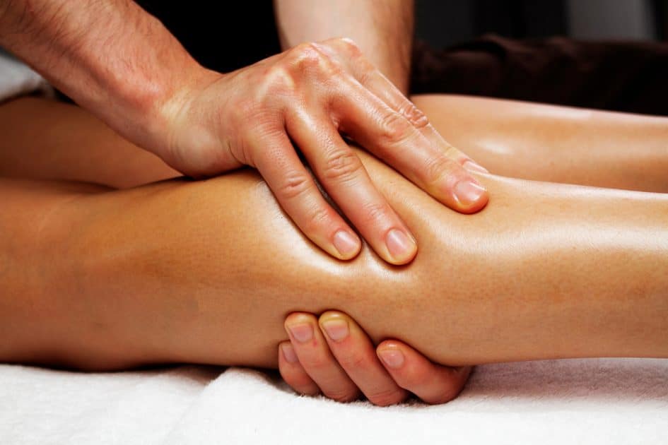 Manual Ligament Therapy of the legs and lower legs. A masseur's hands are on the female feet.

