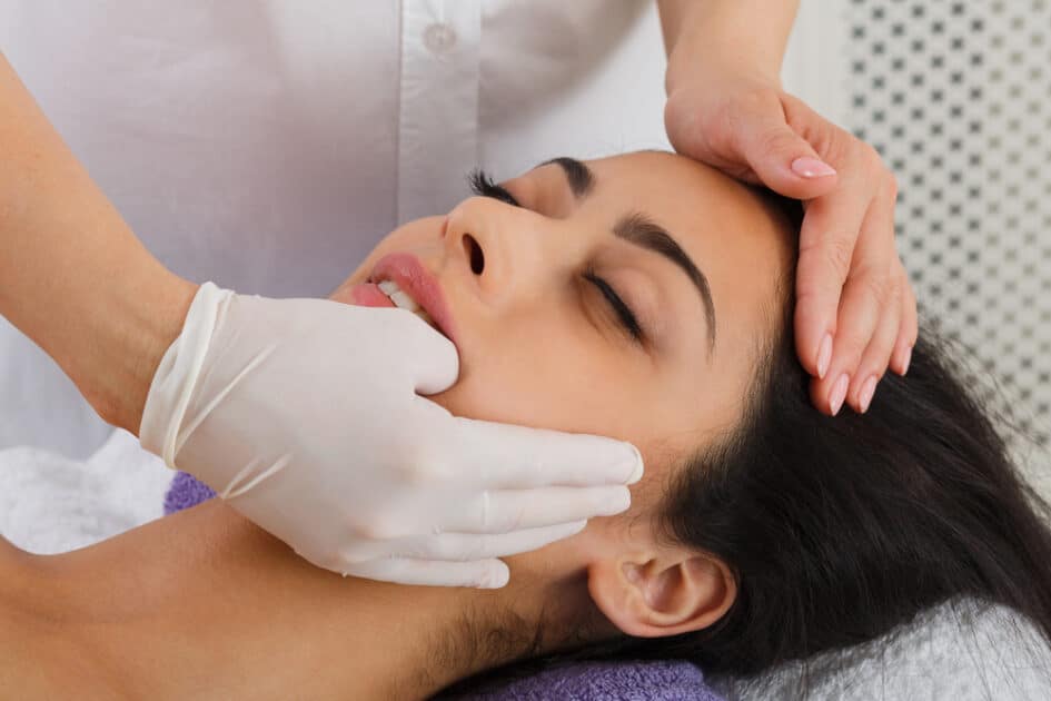 Intraoral neuromuscular massage in a spa. The patient and the doctor are in a wellness center. 