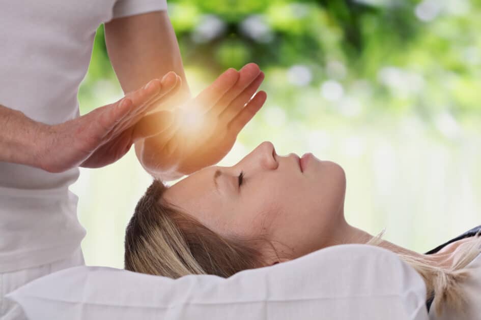 Woman receiving holistic, alternative medicine, and reiki massage healing treatments.
