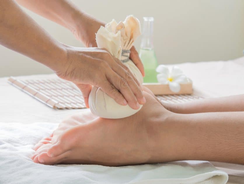 Woman feet having  Herbal Compress Foot Massage
