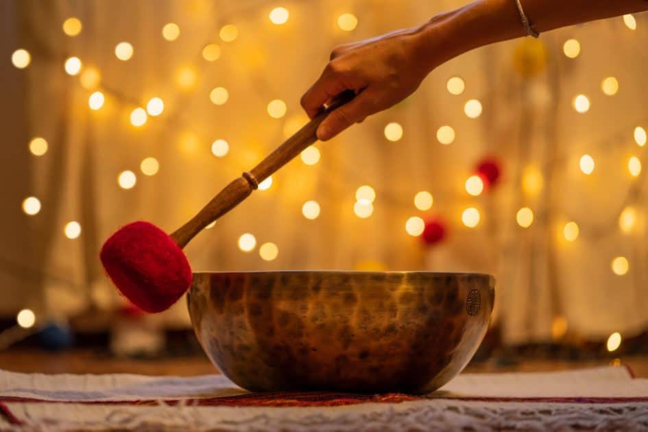On a yellow bokeh background, a singing bowl is seen.