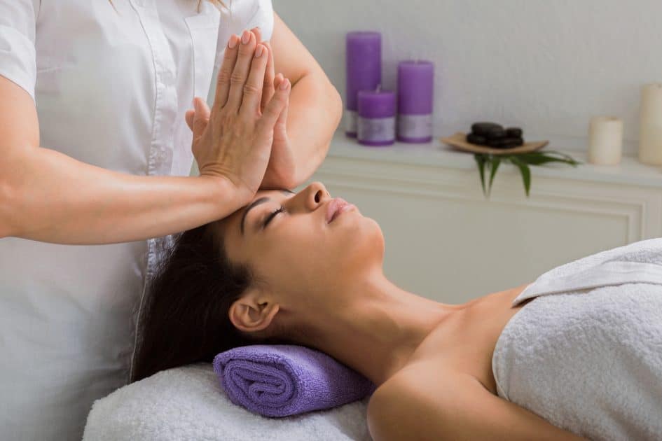 In-spa head and face pummeling massage. In a wellness facility, a female beautician works.
