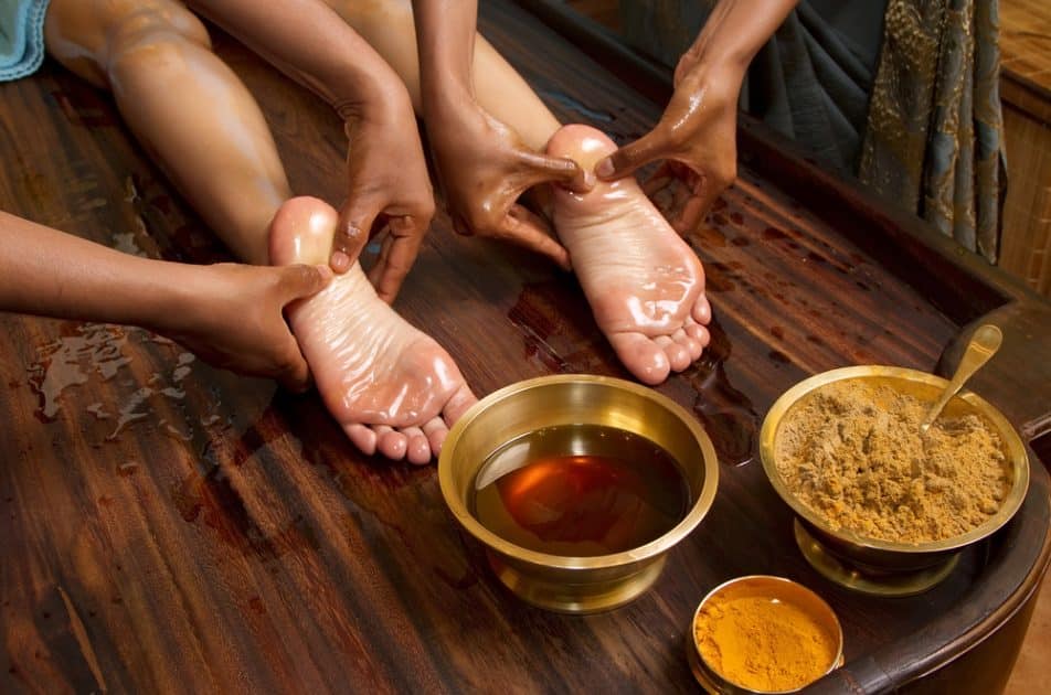 Traditional ayurvedic oil foot massage performed by Indian physicians