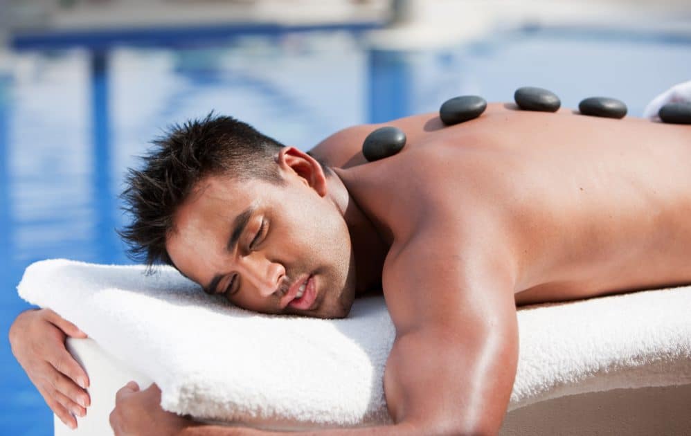 man relaxing with hot stone massage
