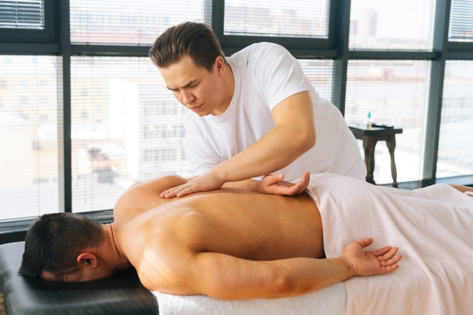 masseur massaging male customer.