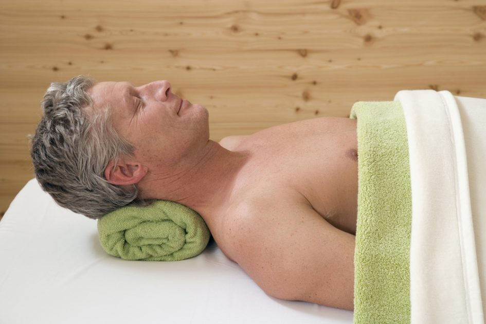 handsome man smiling while relaxing in spa