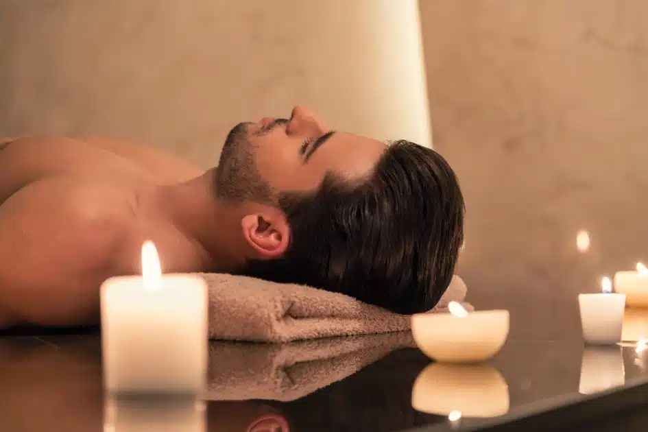 man relaxing with candles